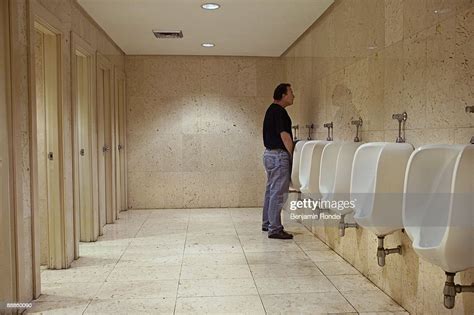 man using urinal in public bathroom photo getty images