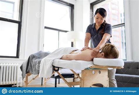 chinese woman massage therapist giving a treatment to an
