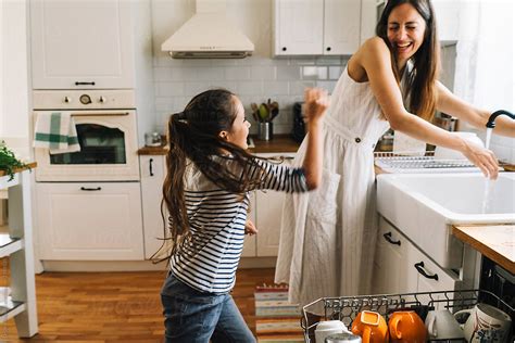 Mother And Daughter Washing Dishes And Having Fun Together By Dejan