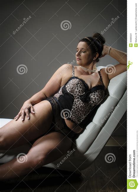 beautiful plus size woman on white armchair stock image