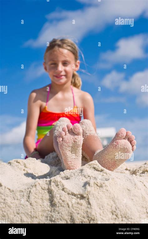 Ein Mädchen Mit Sand Bedeckt Nackten Füßen Sitzt Am Strand