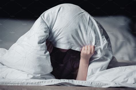 scared child hiding  blanket  people images creative market