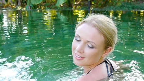 beautiful woman swimming in natural pool water stock