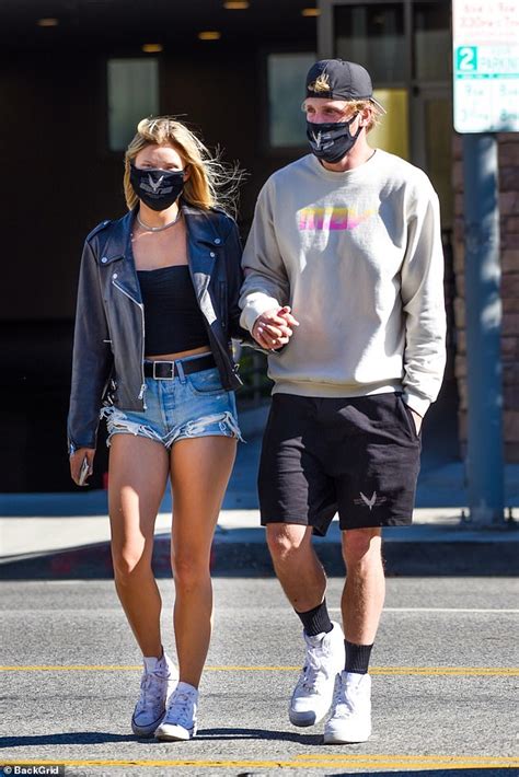 logan paul and josie canseco hold hands and wear matching face masks