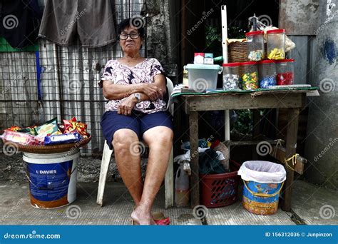 A Filipino Woman Sits And Waits For Customers At Her Makeshift Store