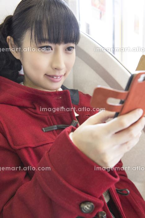 電車でスマホを見る女性の写真素材 [141442010] イメージマート