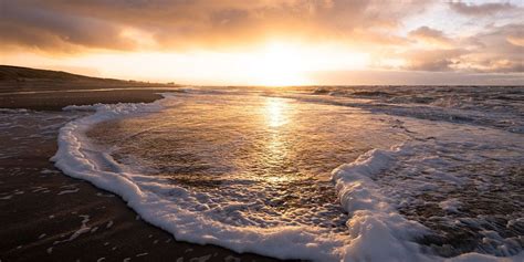 zonsondergang aan de noordzeekust van arjan van duijvenboden op canvas behang en meer