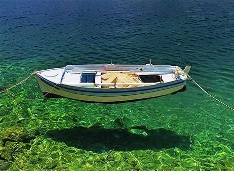 boat floats  crystal clear water photograph  kostas pavlis fine