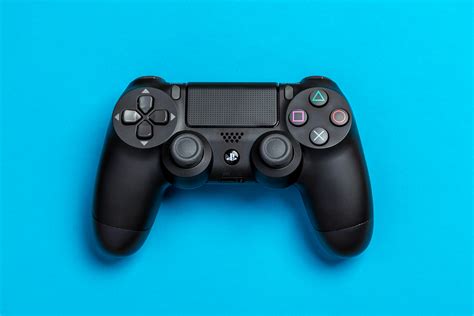 flat lay photo  black sony ps game controller  blue background  stock photo