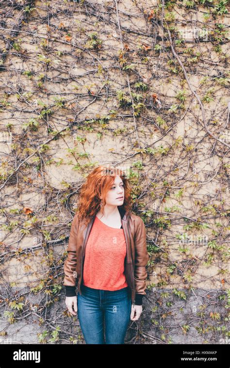 Young Beautiful Redhead Woman Outdoor Looking Over Leaning Against