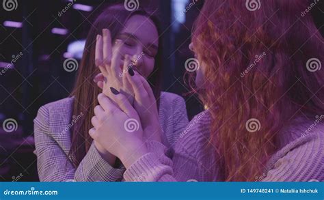 Portrait Of Two Cute Lesbian Girlfriends Holding Hands In Blue Light