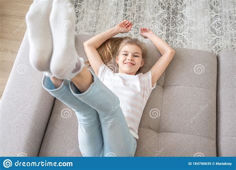 Preteen Girl Lying On Couch With Her Feet Raising Up High Stock Image