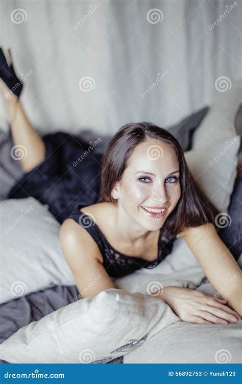 Young Brunette Woman In Loft Laying On Bed Smiling Stock Image Image