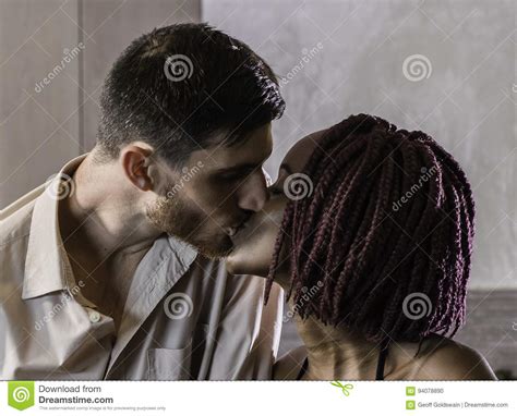 happy mixed race couple sharing a kiss in the kitchen