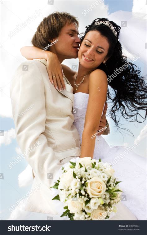 Bride And Groom Kissing On The Blue Sky Background Stock