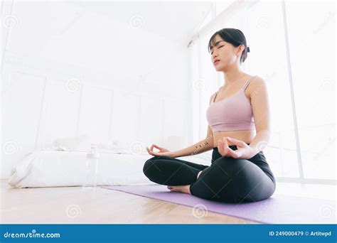 Young Attractive Sporty Asian Woman Practicing Yoga On A Yoga Mat