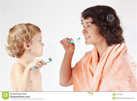 mother teaches her little son to brush their teeth stock images image