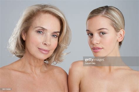 portrait of smiling bare chested mother and daughter stock