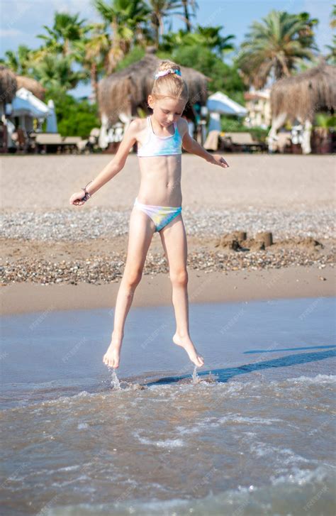 premium photo  girl   bathing suit playing   beach   sea