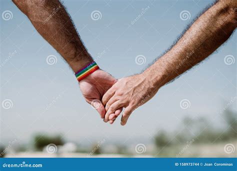 Closeup Of A Gay Couple Holding Hands Rainbow Flag Is A Symbol Of