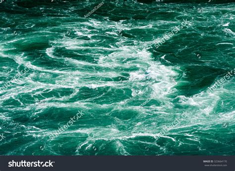 abstract powerful white water currents churning  flowing green river stock photo