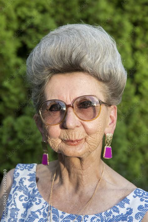 portrait of an over 70 years old woman wearing glasses looking at