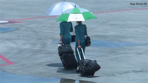 pramugari garuda indonesia berjalan kaki dengan payung menuju pesawat di bandara int lombok