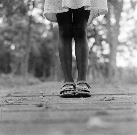 black girl s feet on a wooden boardwalk in a forest by stocksy