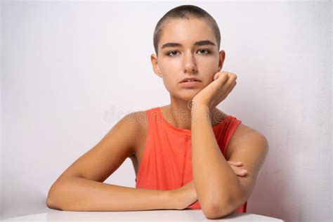 Caucasian Girl With Short Hair Almost Bald Holds Her Hands Behind Her