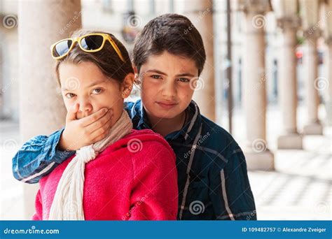 child covers  mouth   sister portrait stock image image