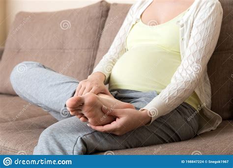 leg cramps during pregnancy closeup of hands massaging swollen foot