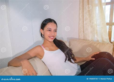 Happy Woman Sitting On The Couch The 20 Year Old Latina Woman Enjoys