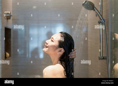 Young Asian Woman Taking A Shower In The Bathroom With Shower Head