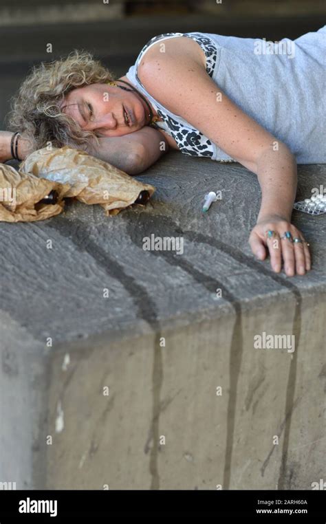 A Drunk Homeless Woman Sleeping Under A Bridge With Bottles Of Alcohol