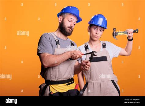confident constructors holding renovating tools on camera using