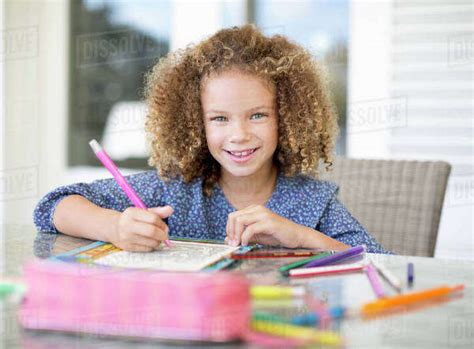 girl coloring  table stock photo dissolve
