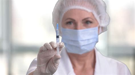 woman doctor preparing syringe for injection female doctor or nurse