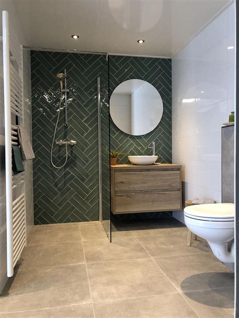 fantastische badkamer met een dubbele visgraat tegel  groen eiken badmeubel met waskom en