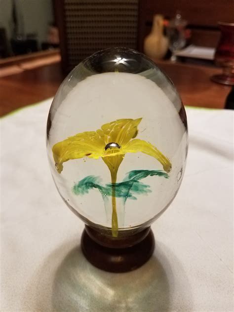 egg shaped paperweight  wood base  flower origin antiques board