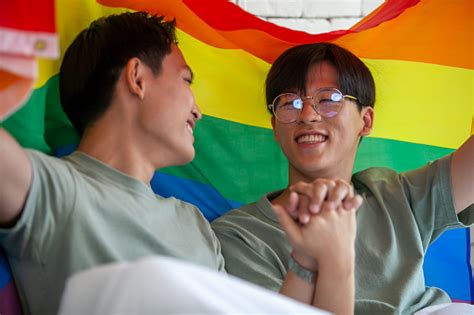 Happy Asian Gay Couple Holding Hands Together Relaxing At Home On Bed