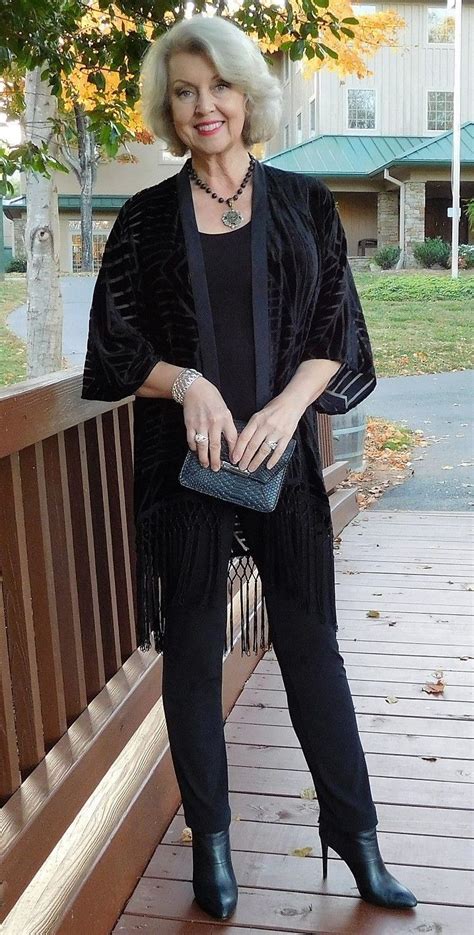 an older woman standing on a porch holding a purse