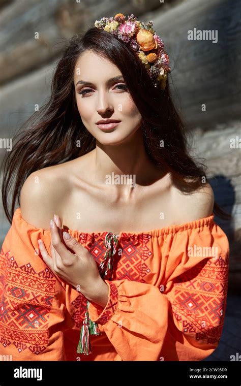 Beautiful Slavic Woman In An Orange Ethnic Dress And A Wreath Of
