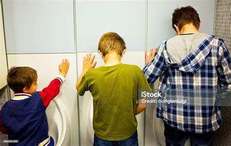 three siblings in decreasing scale pissing public urinals from behind