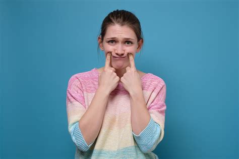 Young Upset Woman Making Fake Smile With Her Fingers Stretching The