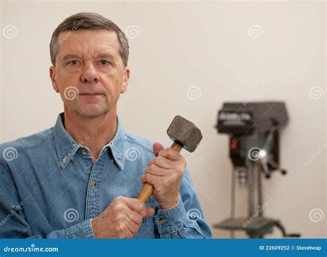 senior man holding  large hammer stock photography image