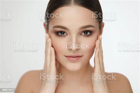 beauty woman face girl with natural makeup touching facial skin stock