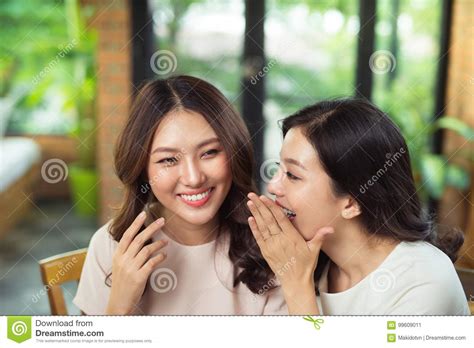 twee aziatische en vrouwenvrienden die babbelen gossipping