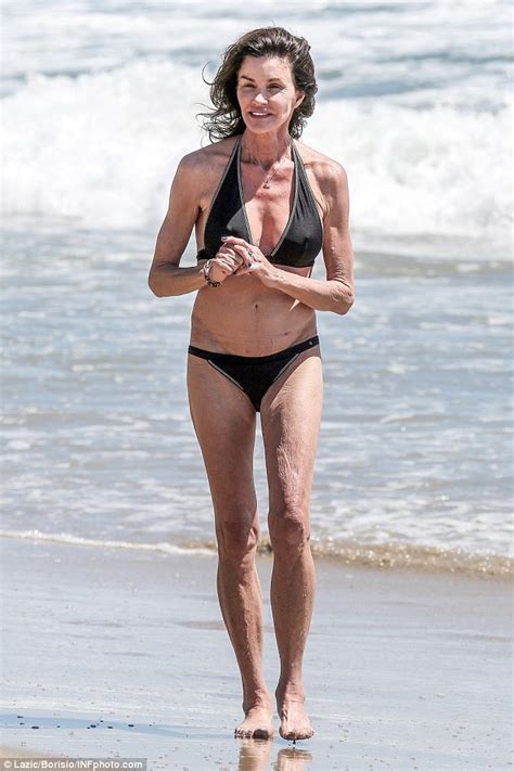 cbb s janice dickinson frolics on the beach in malibu in a black bikini