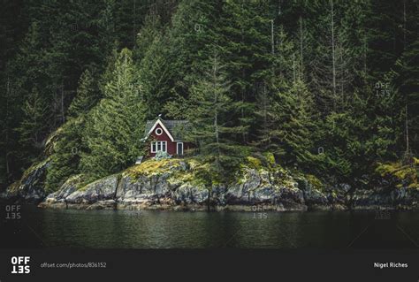 red secluded cabin   waters edge   forest stock photo offset