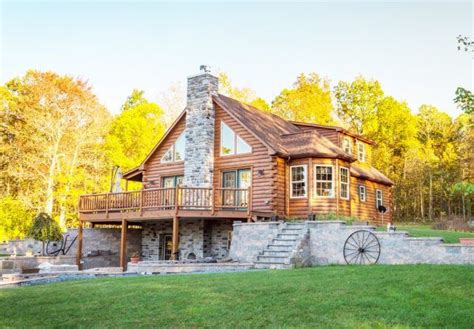 log cabin sits   middle   grassy area  stairs leading